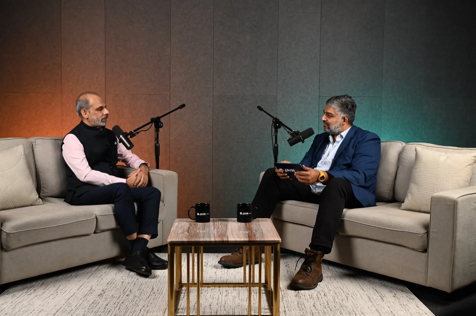 Two people in a seated conversation during a studio interview