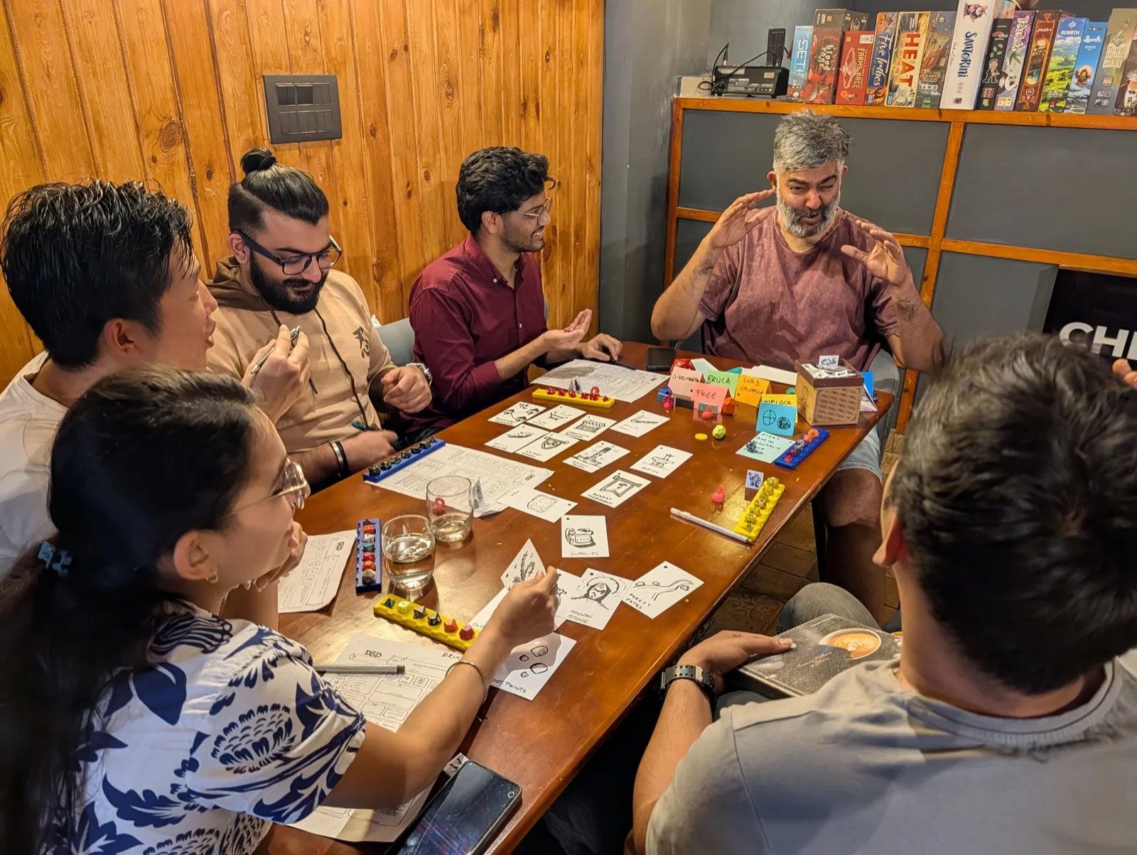 Group of adults playing a board game together at a games table