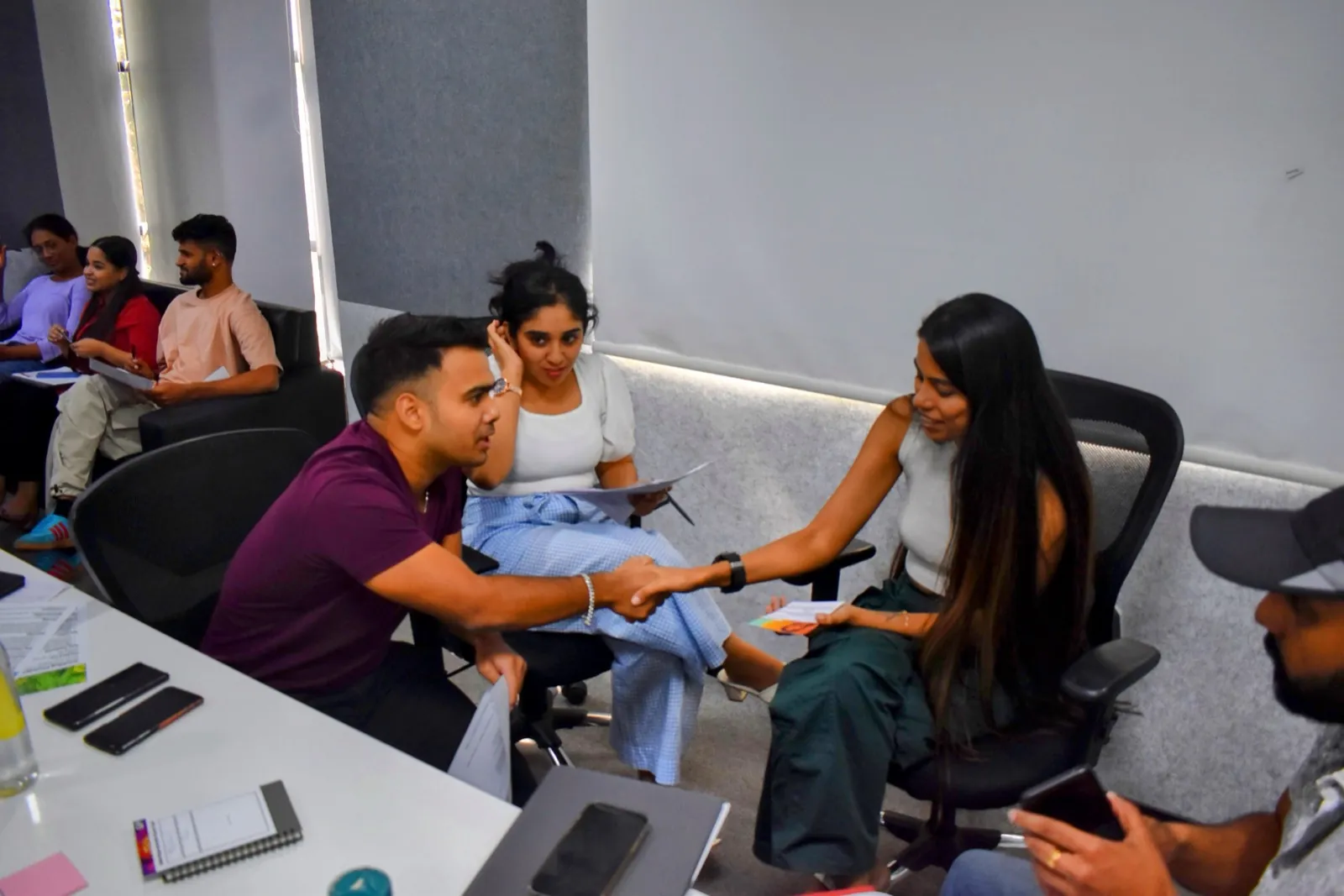 Two participants shaking hands during a team workshop