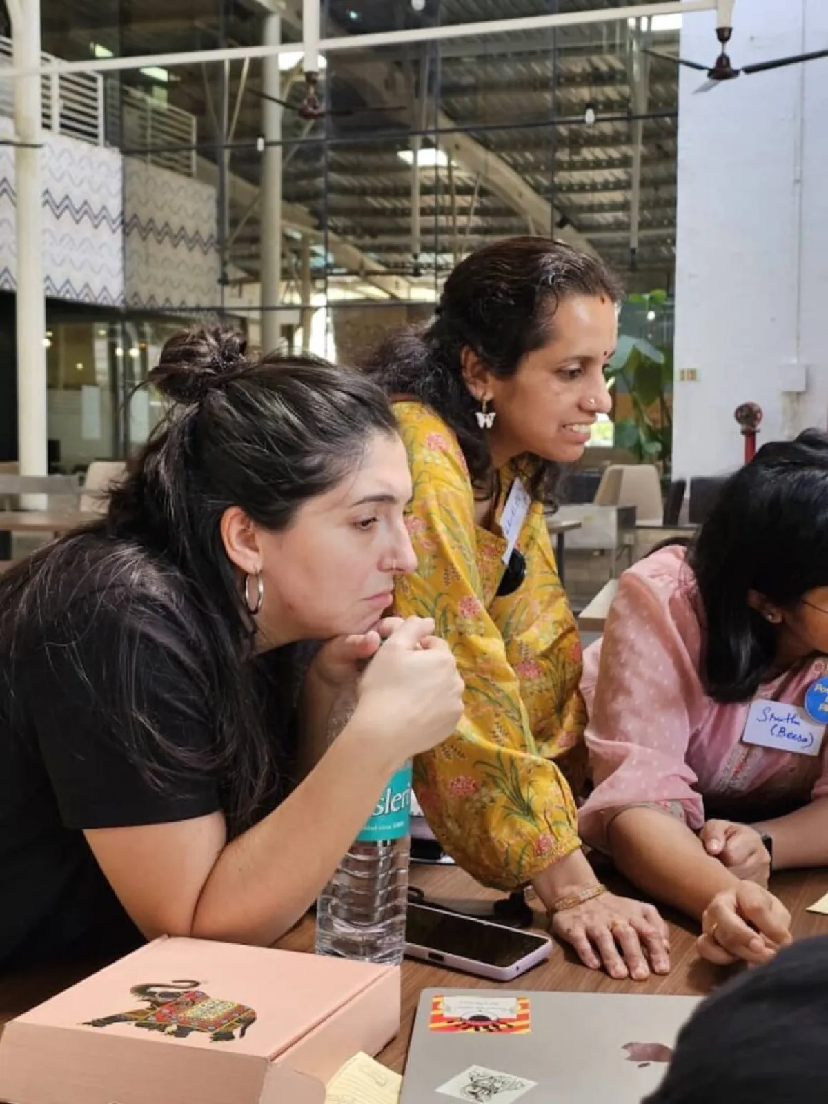 Two participants closely examining game pieces during a workshop