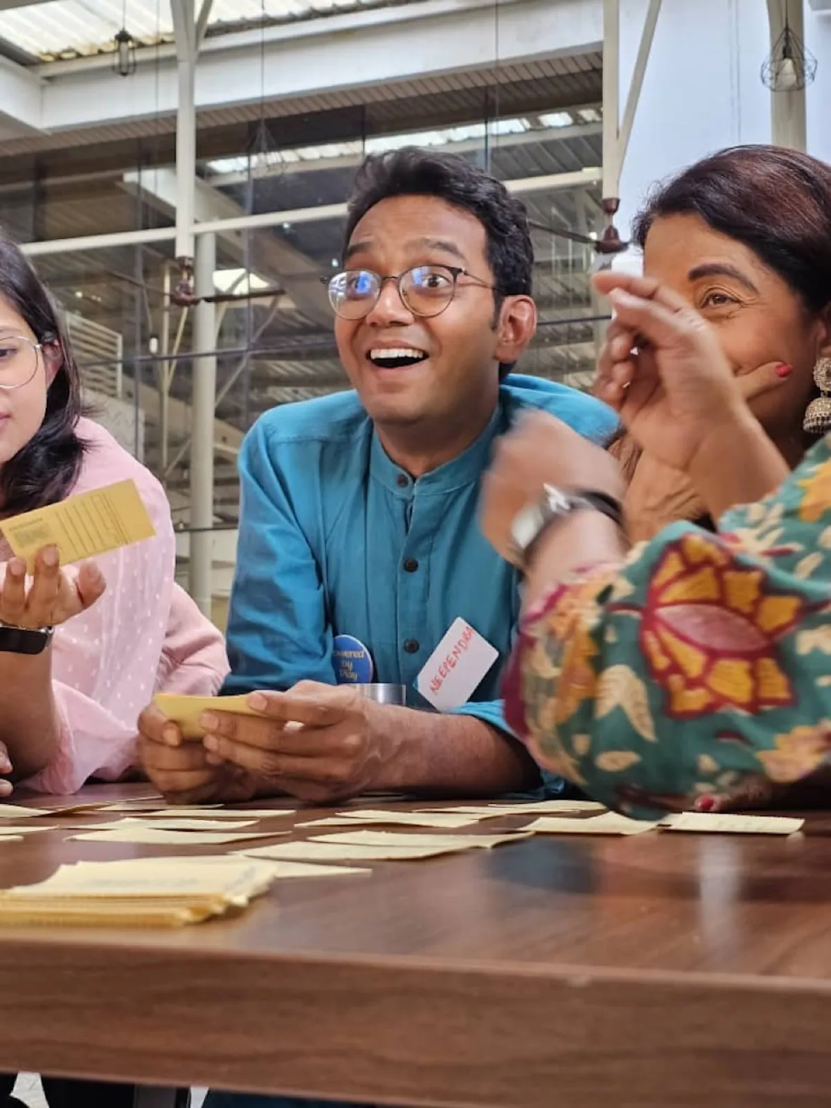 Participants laughing while playing a card game at a workshop